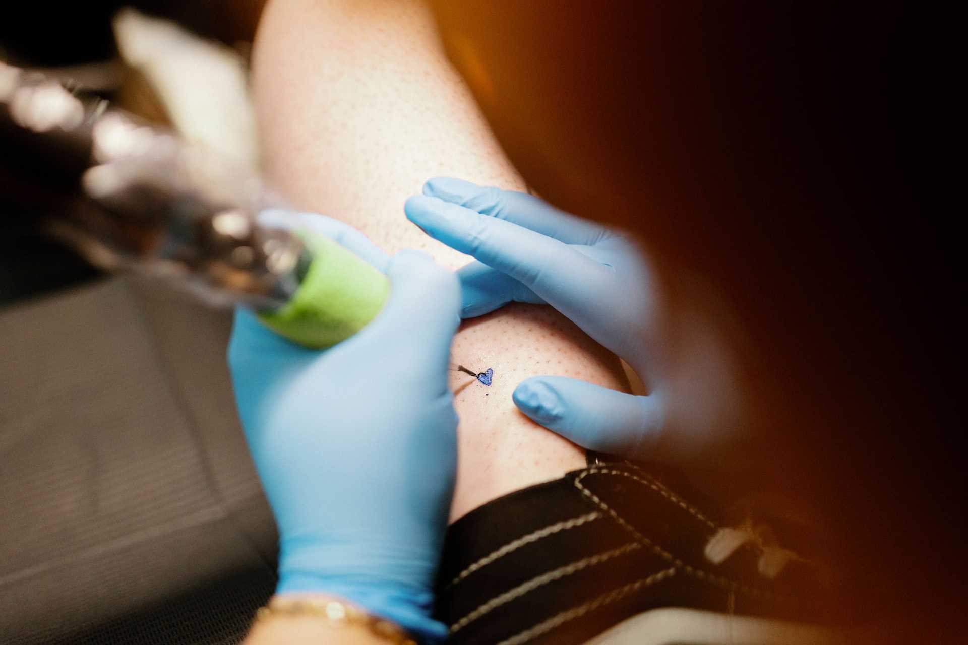 Close-up of a tattoo being inked on someone's leg.